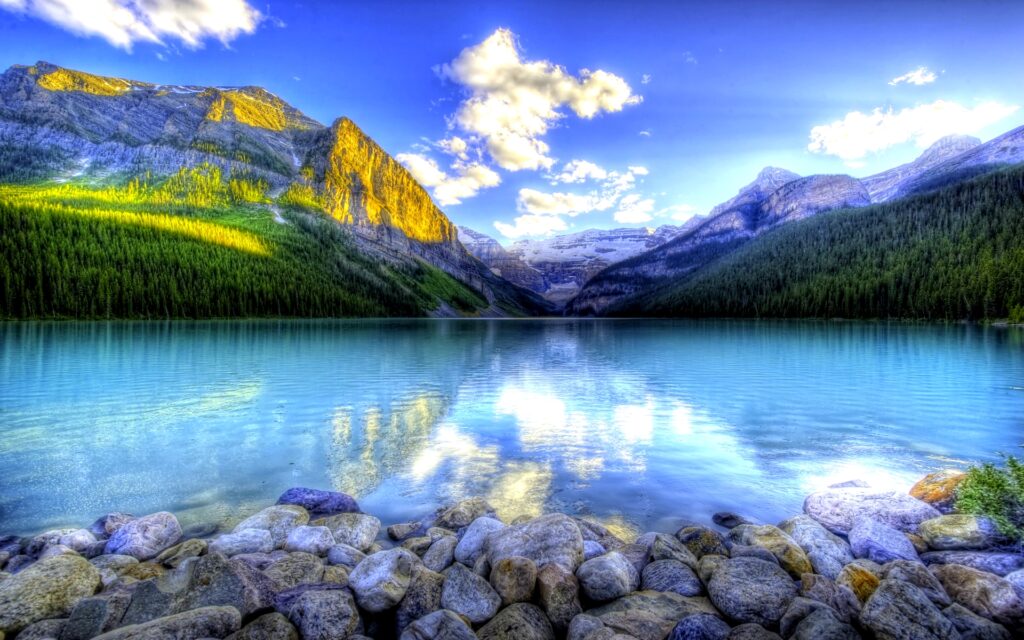 Peaceful calm mountain lake with blue sky and clouds
