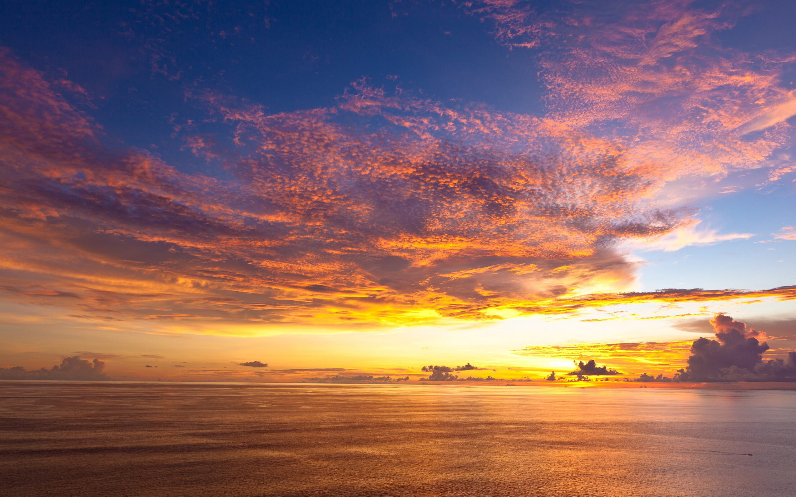 Peaceful clouds over the sea with warm sunlight in the distance