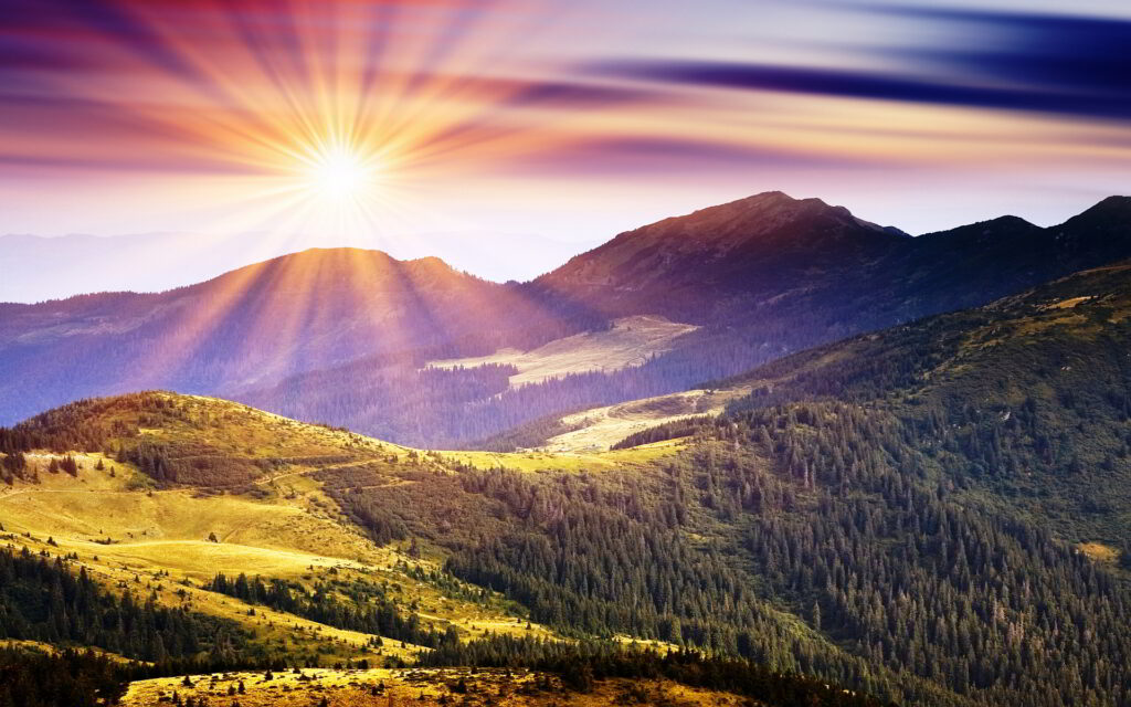 The sun shining forth dazzling rays of light with peaceful rolling hills and trees